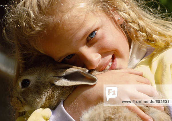 Mädchen umarmendes Kaninchen  Nahaufnahme
