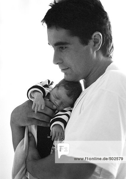 Mann umarmt Baby  Seitenansicht  s/w