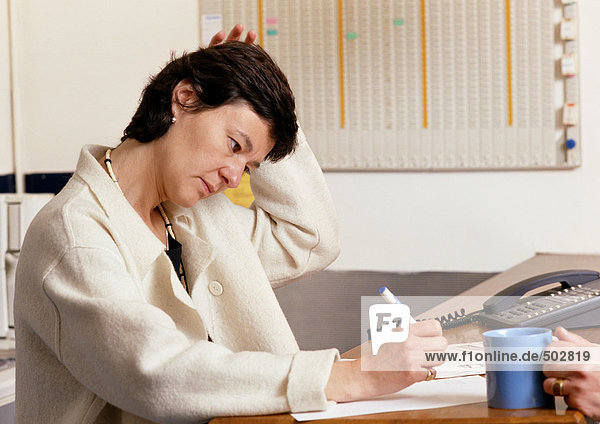 Woman sitting at desk  writing