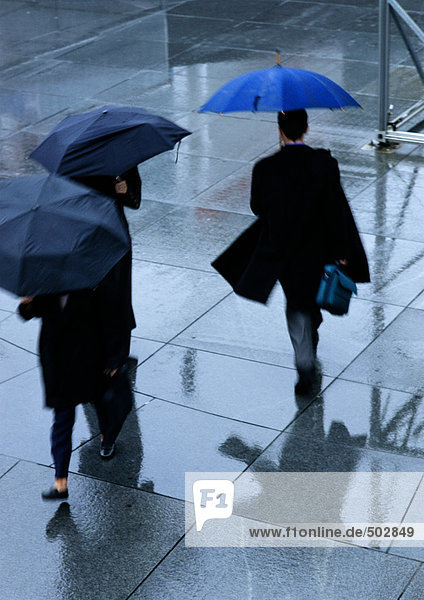 Drei Personen halten Regenschirme in der Straße hohe Blickwinkel