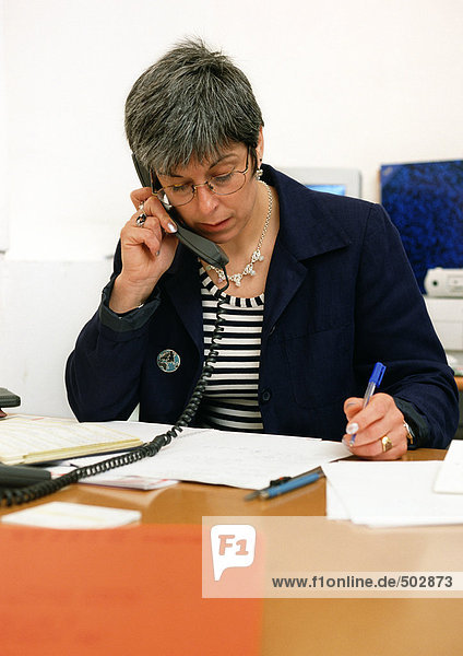 Woman sitting at desk  telephoning