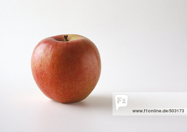 Roter Apfel in aufrechter Position  weißer Hintergrund