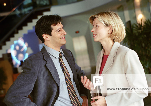 Businessman and businesswoman standing face to face  smiling