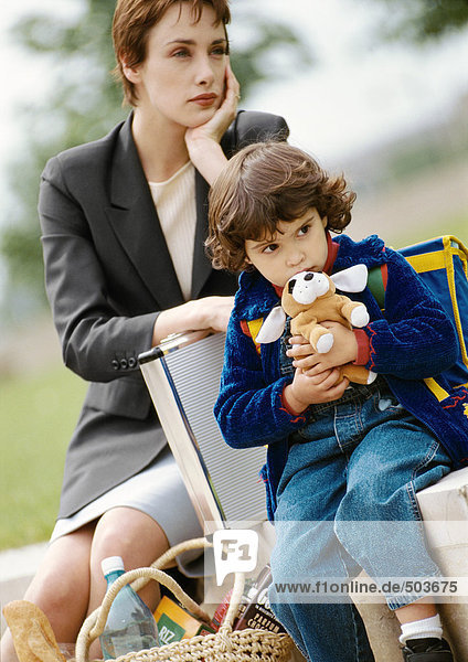 Geschäftsfrau und Kind sitzend,  Kind umarmend ausgestopfter Hund