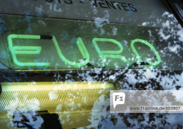 Euro-Text  Neonschrift und Baumreflexion auf Glas  Nahaufnahme