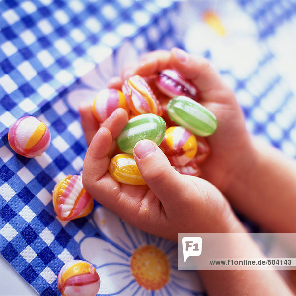 Kinderhände mit Süßigkeiten  Nahaufnahme