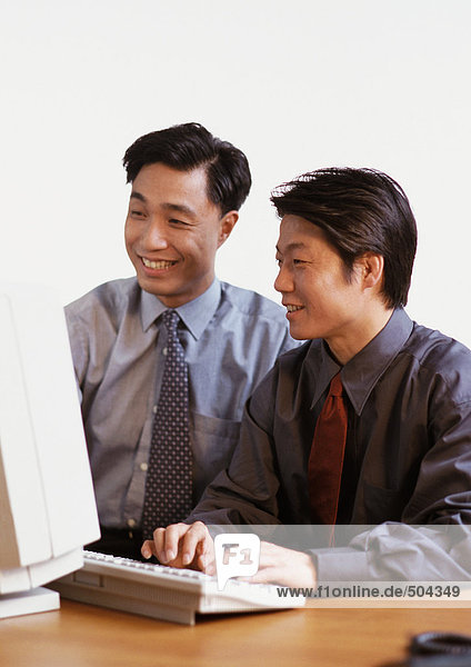 Zwei Männer schauen auf den Computerbildschirm