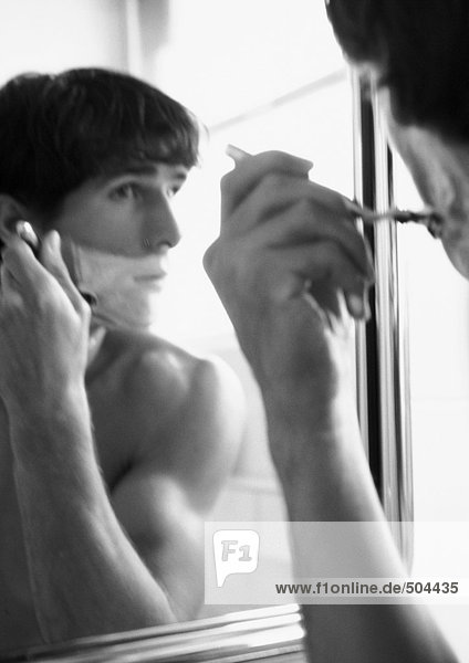 Mann rasiert sich im Spiegel  s/w