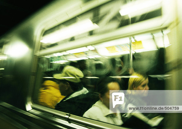 Menschen in der U-Bahn,  von außen betrachtet,  verschwommen