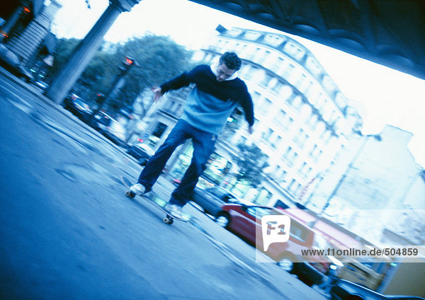Junger Mann beim Skateboarden auf der Straße