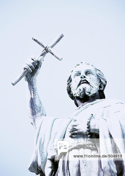 Statue of man holding crucifix  low angle view