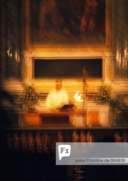 Priest behind altar  blurred