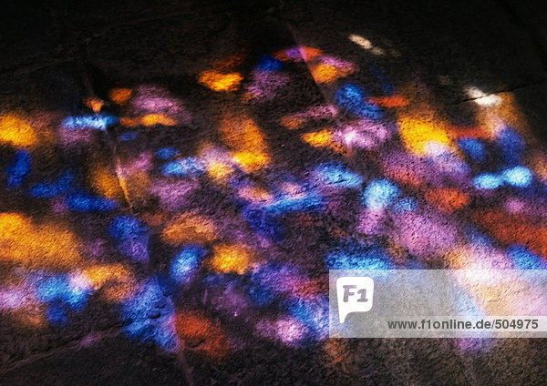 Colored light on ground  reflected from stained glass window  close-up