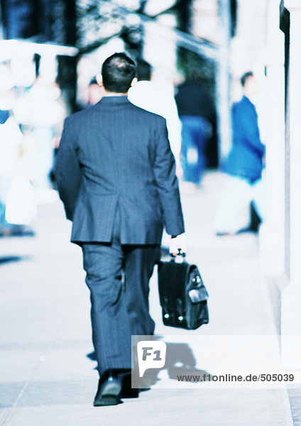 Businessman walking in street  rear view