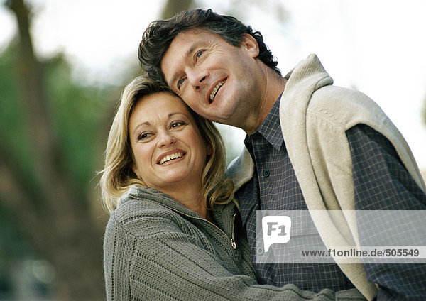 Mann und Frau halten sich gegenseitig  lächelnd  Kopf und Schultern