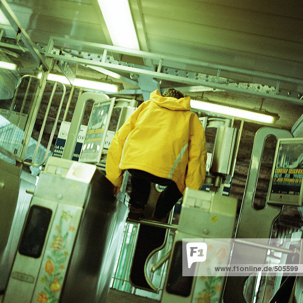 Junger Mann springt über Drehkreuz in der U-Bahn
