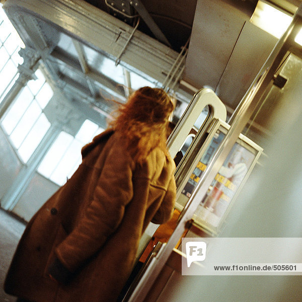 Junge Frau geht durch Türen in der U-Bahn-Station