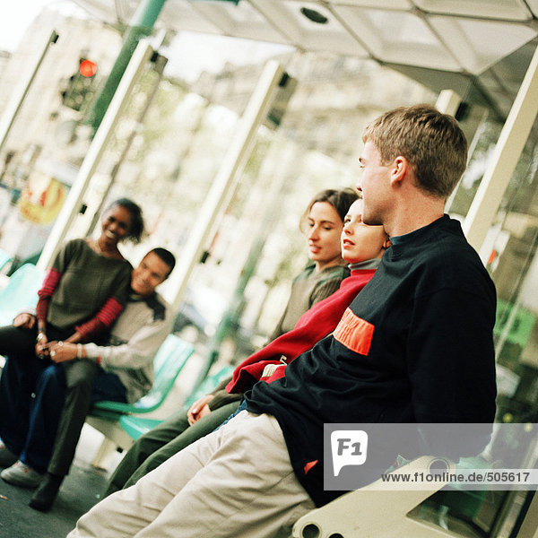 Young people sitting in bus station
