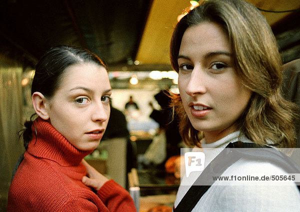Zwei junge Frauen im Geschäft  mit Blick auf Kamera  Kopf und Schultern  Nahaufnahme.