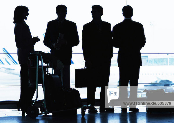 Group of business people standing inside airport  silhouette.