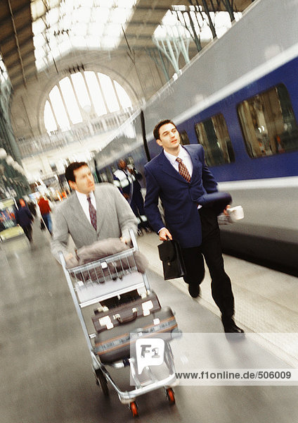 Businessmen running on train platform  blurred.