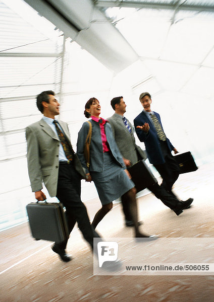 Group of business people walking together indoors  blurred.