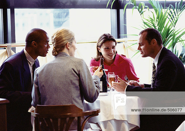 Group of business people sitting at table  eating