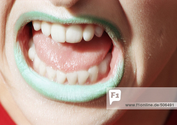 Close up of woman's mouth open with green lipstick., mouth