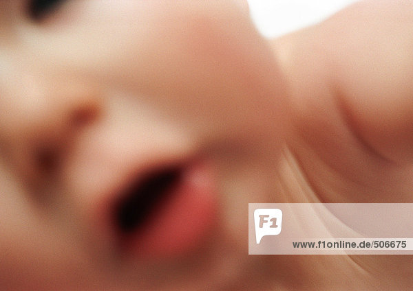 Teilansicht des Gesichts des Babys  Mund offen  verschwommen.