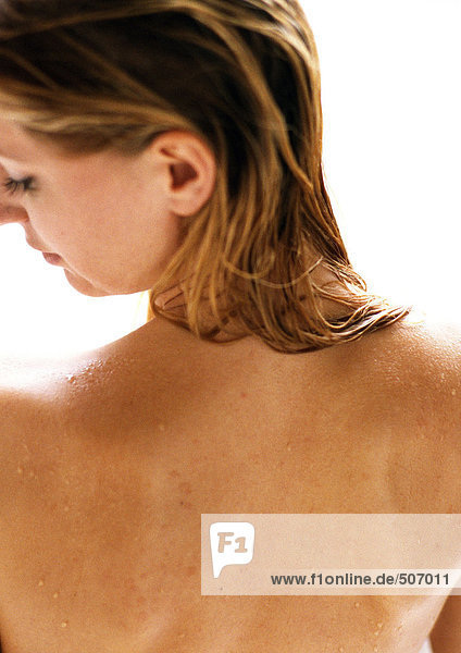 Frau mit nacktem Rücken  Kopf zur Seite gedreht  Rückansicht  Nahaufnahme