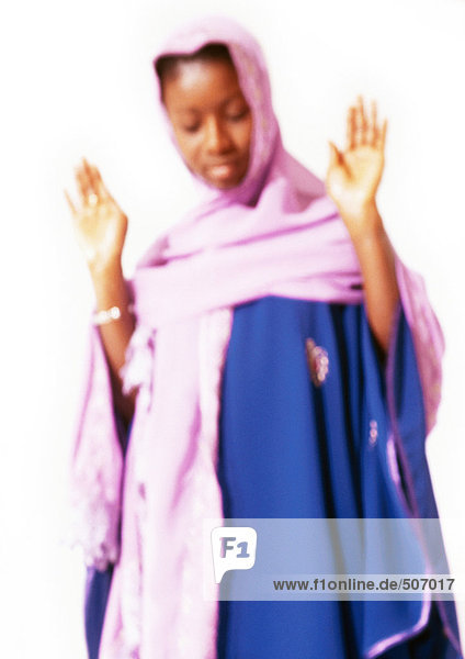 Muslimische Frau mit erhobenen Händen im Gebet  verschwommen.