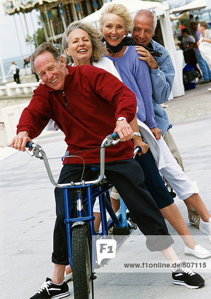 Mature men and women on stationary tandem bike  portrait