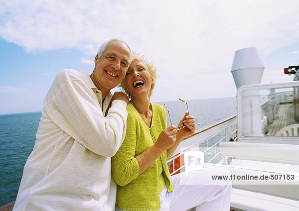 Mature couple posing on boat deck  laughing