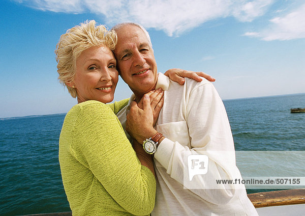 Mature couple embracing on boat deck