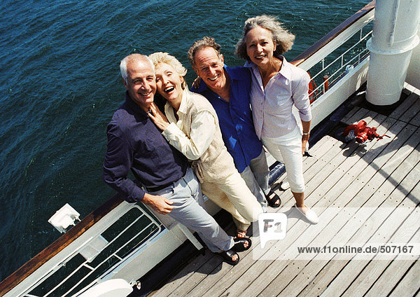 Reife Paare  die neben dem Geländer des Bootes stehen  mit Blick auf die Kamera  Porträt  Hochwinkelaufnahme