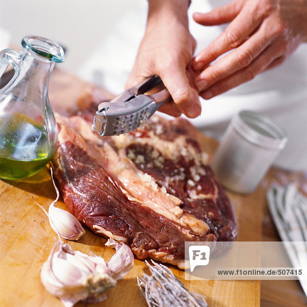 Nahaufnahme eines Ribeye-Steaks mit zerdrücktem Knoblauch