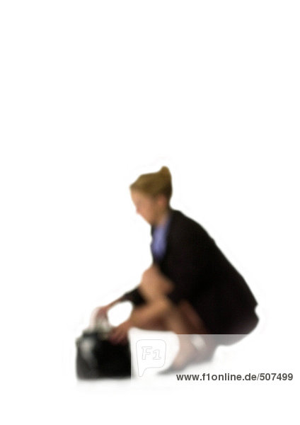 Silhouette der Frau  die neben der Handtasche sitzt  auf weißem Hintergrund  defokussiert