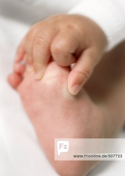 Baby's hand holding foot  close-up
