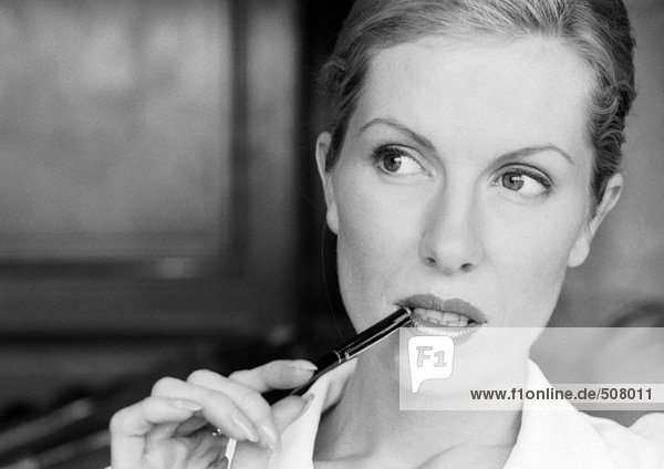 Geschäftsfrau hält Stift an Mundwinkel  Nahaufnahme  B&W
