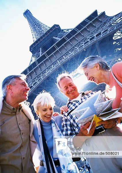 Frankreich  Paris  reife Touristen  die eine Karte vor dem Eiffelturm begutachten  Tiefblick