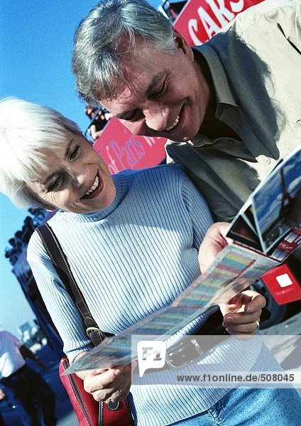 Reife Frau und Mann beim Betrachten einer Broschüre  Nahaufnahme