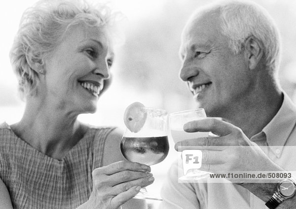 Mature man and woman clinking glasses  close-up  B&W