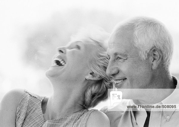 Mature man and woman smiling  woman with head back  close-up  B&W