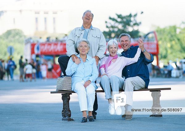Gruppe reifer Menschen auf einer Bank  lächelnd vor der Kamera  Porträt