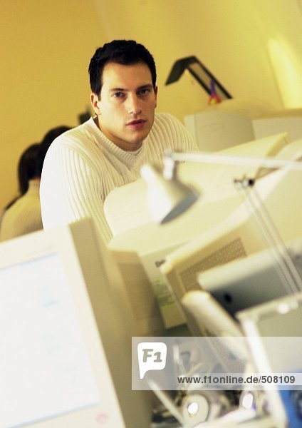 Man behind computers in office  portrait