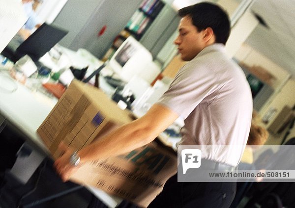 Man placing box on desk  blurred