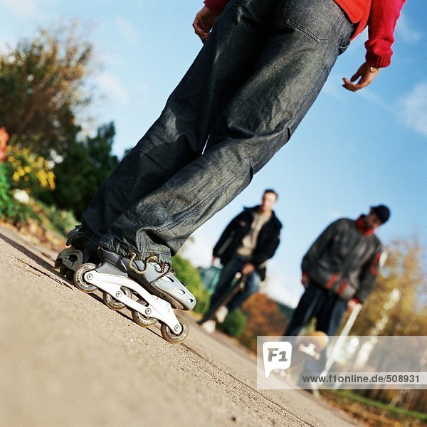 Jugendliche  auf Inline-Skates  andere mit Skateboard  niedrige Sektion