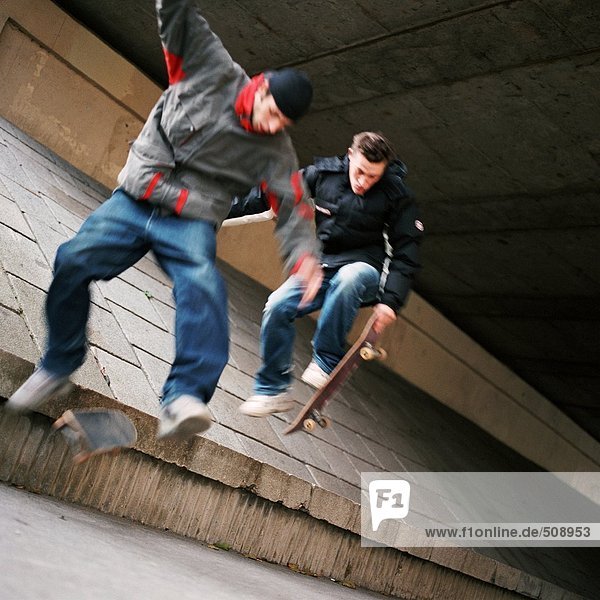 Junge Männer in der Luft springen mit Skateboards  verwischt