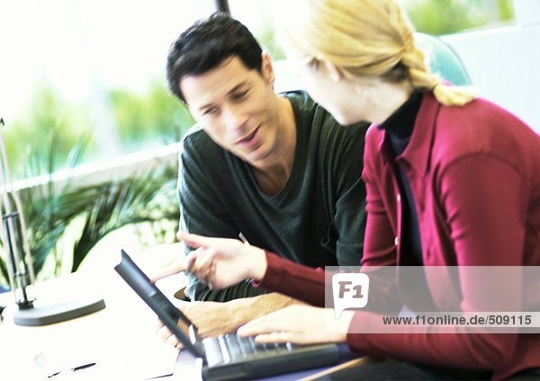 Geschäftsmann und Frau mit Laptop-Computer