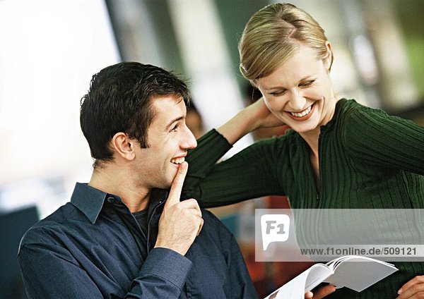 Geschäftsmann und Frau  die das Buch anschauen  lächelnd